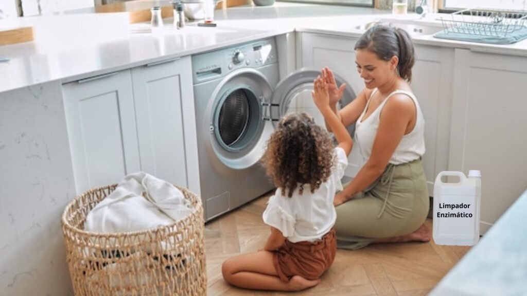 O Poder dos Removedores Enzimáticos no Bem-Estar Familiar: 01 Combinação Perfeita. 10 Mãe e filha pequena sorrindo e batendo palmas felizes na área de serviço enquanto terminam de usar removedor enzimático na máquina de lavar roupas brancas, simbolizando o Poder dos Removedores Enzimáticos no Bem-Estar Familiar em uma casa limpa, alegre e livre de odores.